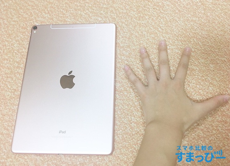 ipadproと自分の手を比べている